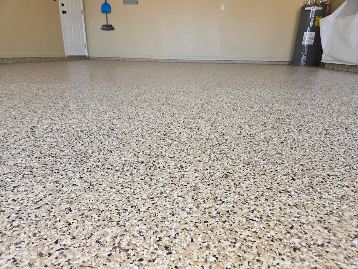 After: tan and white flake garage floor coating with coated baseboards