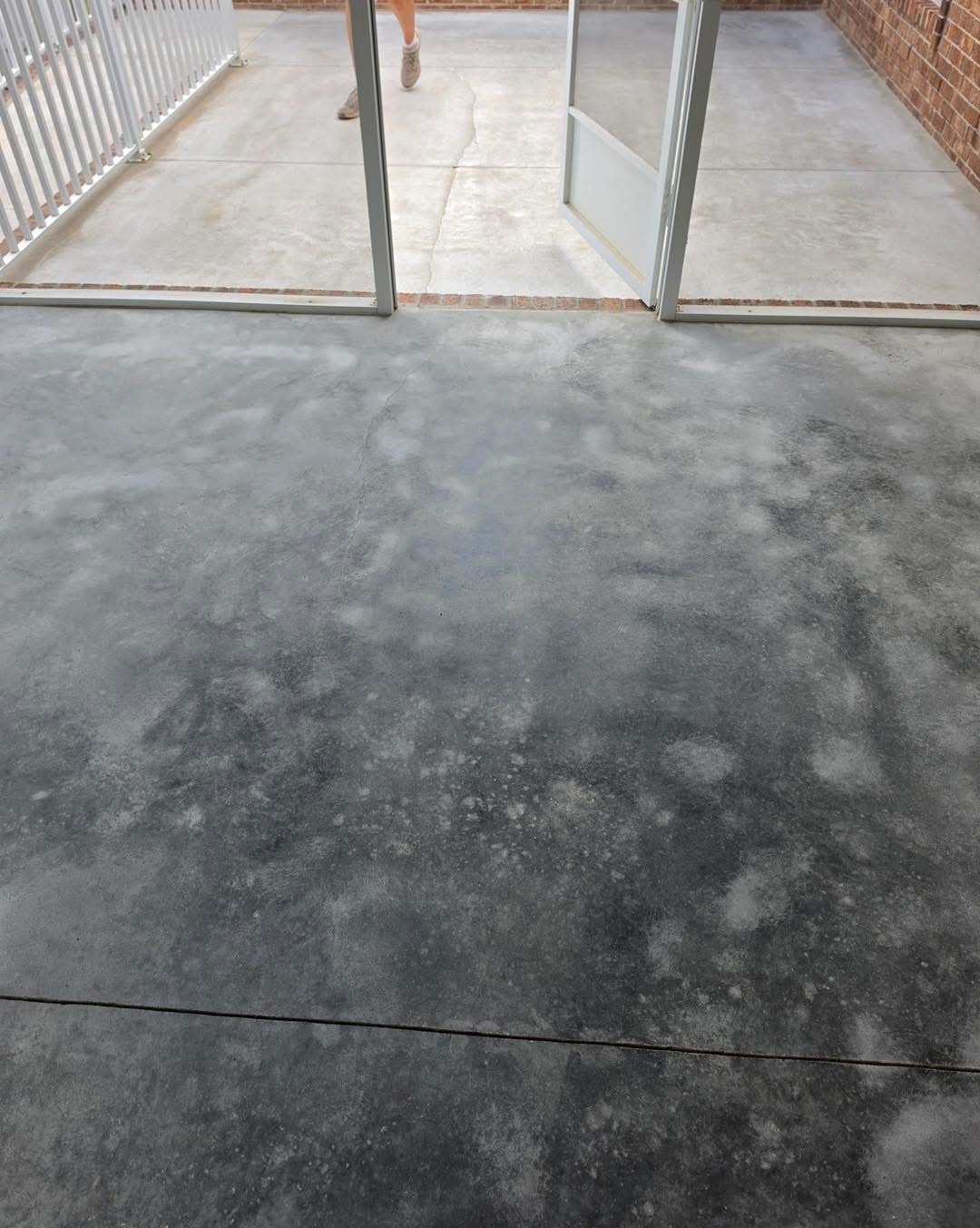 Before: bare concrete sunroom floor with staining