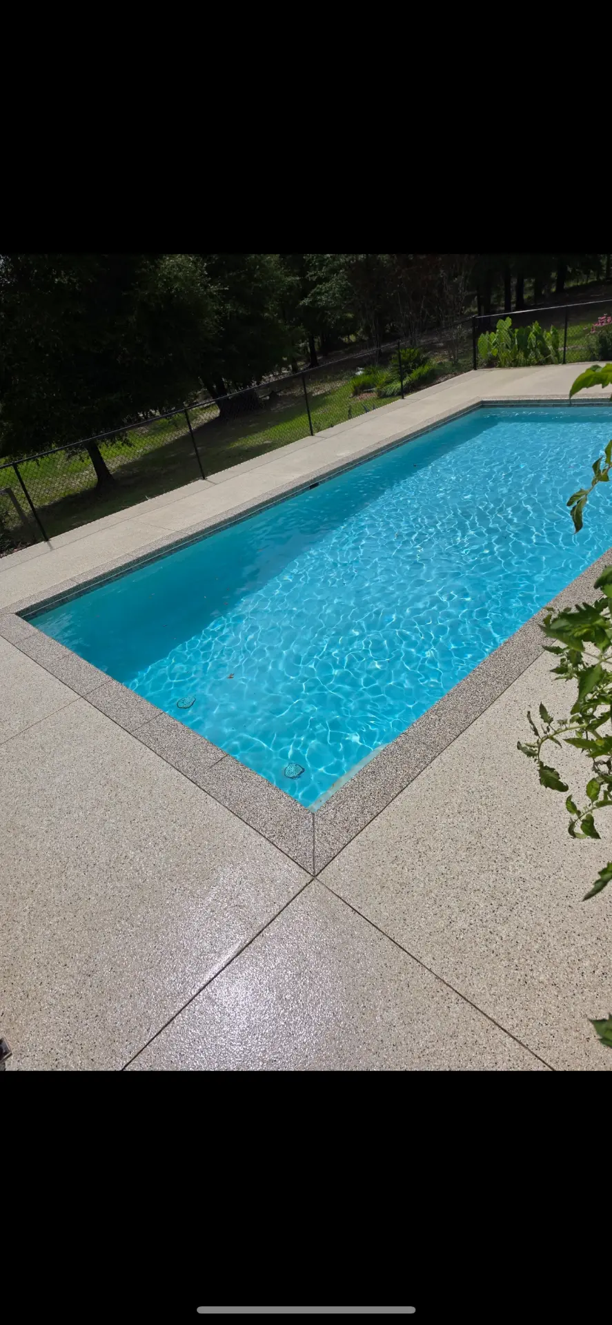 Coated pool deck surrounding a bright blue swimming pool