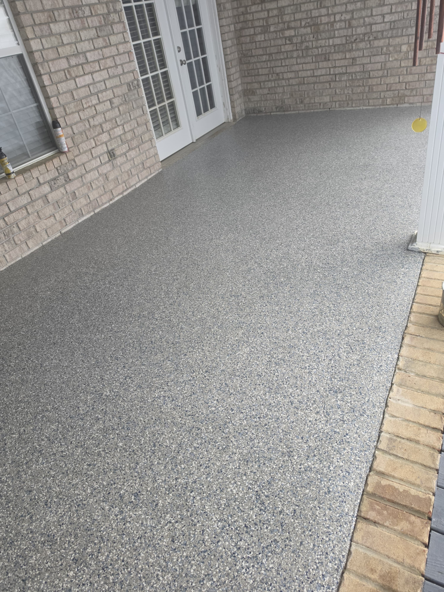 After: gray flake coating on the same back patio