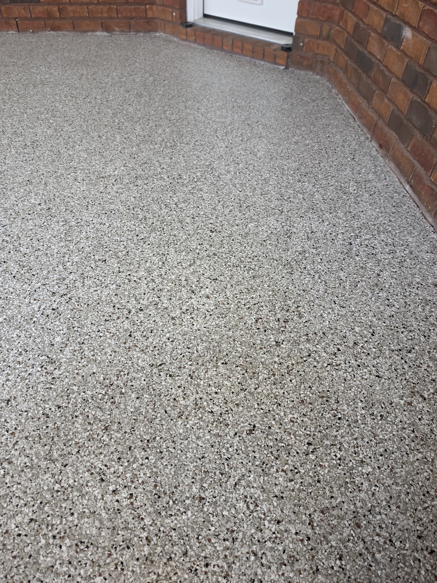 Wide view of the finished gray flake coating around a brick corner