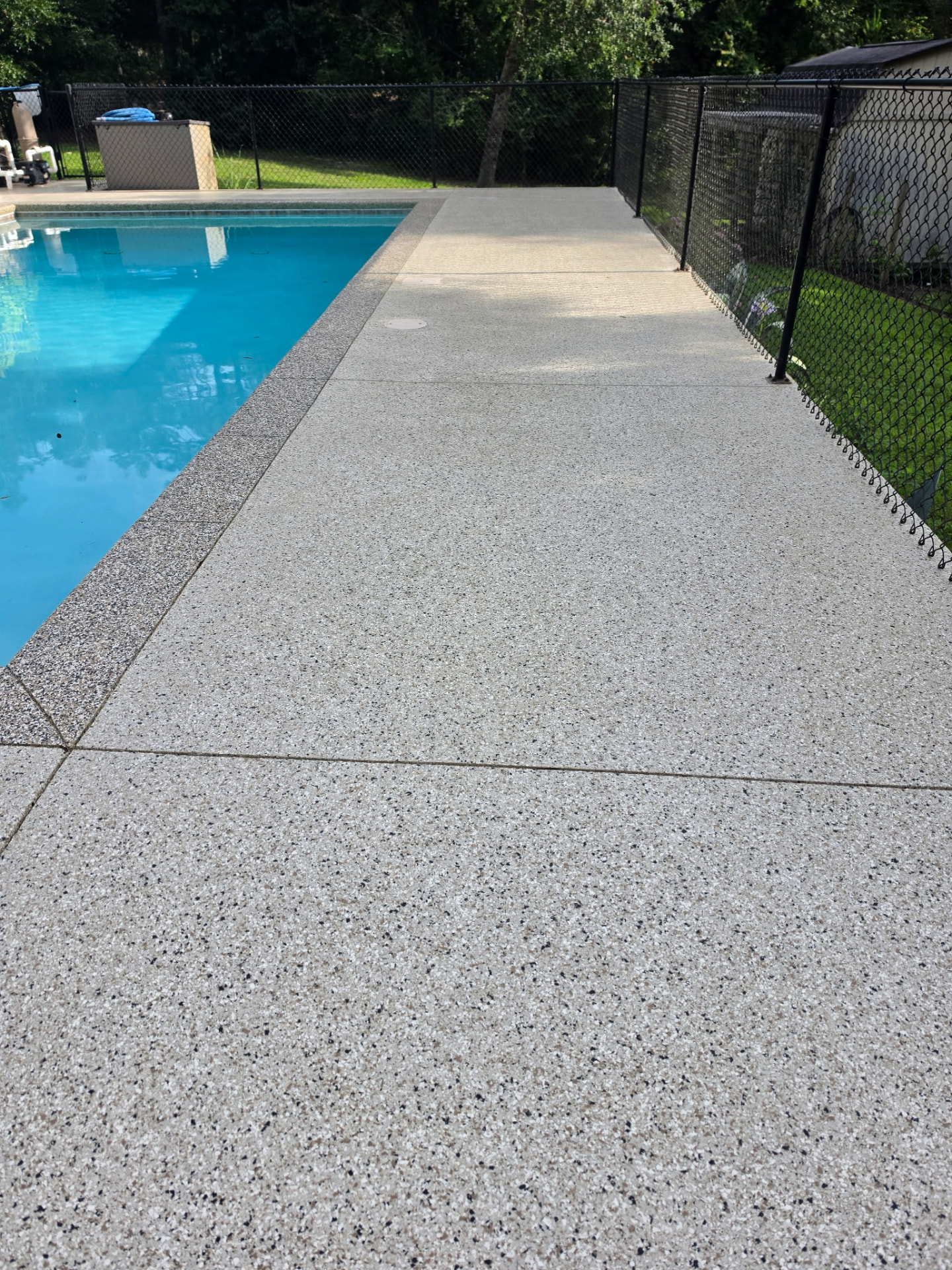 Slip-resistant coated pool deck alongside clear water
