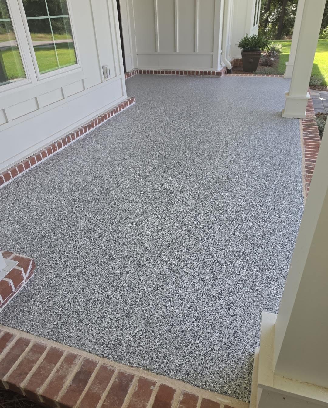 Finished gray flake-coated front porch with brick border