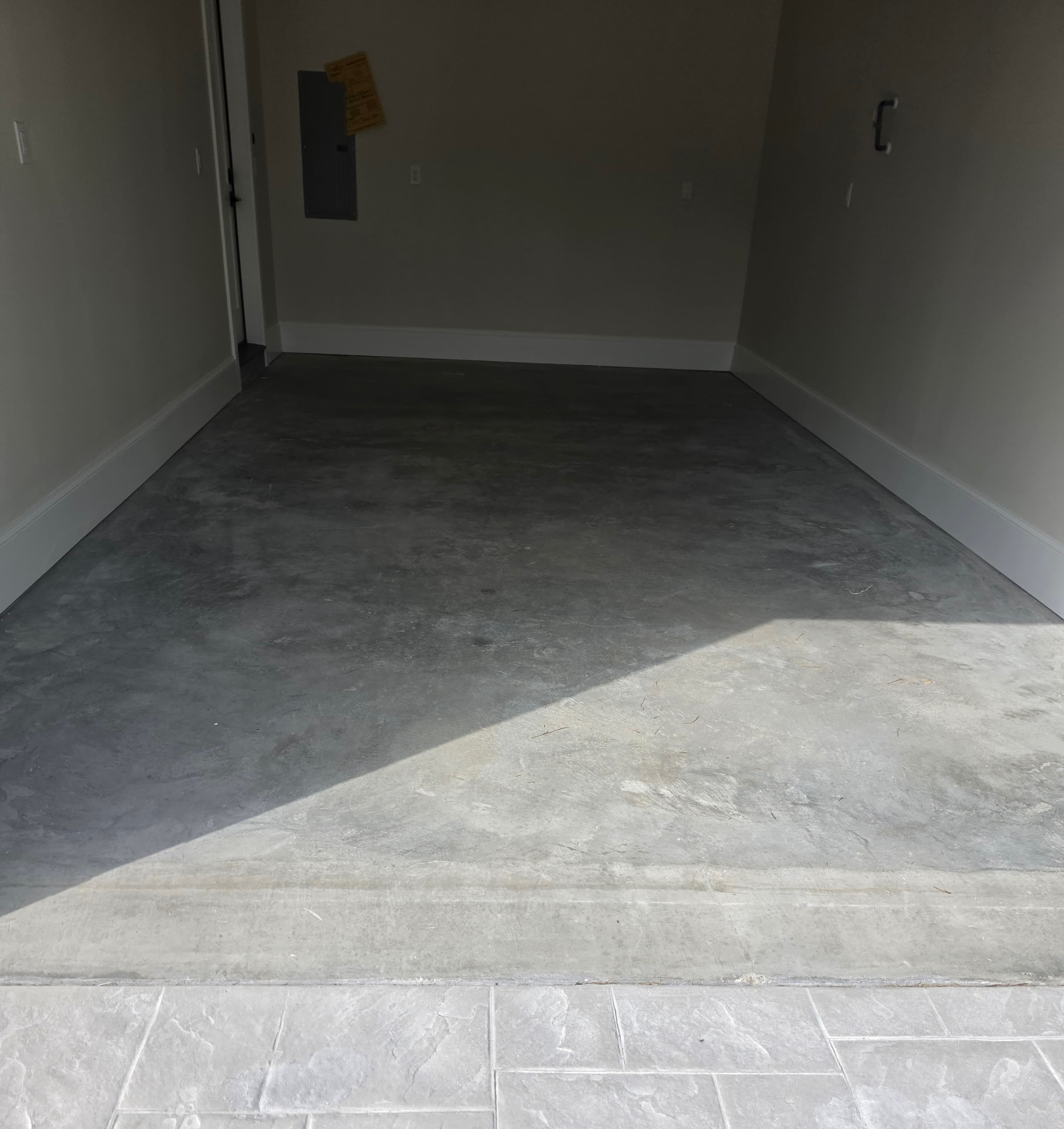Before: bare gray garage concrete with staining and surface wear