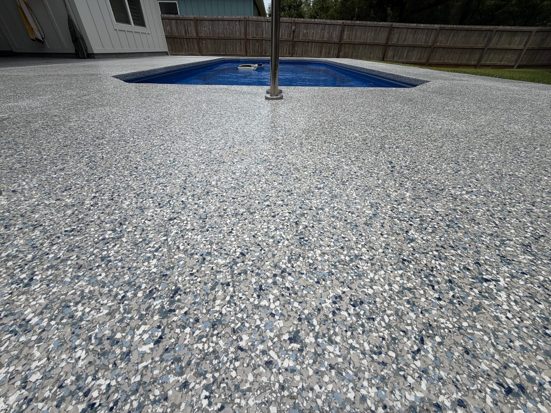 Finished flake coating surrounding a residential pool
